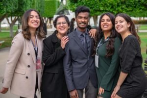 A group of diverse colleagues smiling together, showcasing teamwork and friendship outdoors.